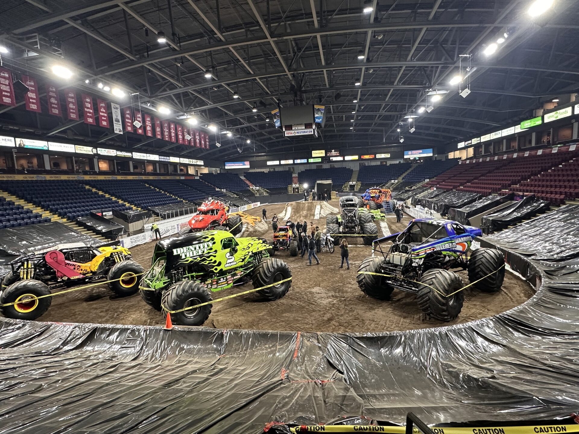 A thrilling scene in an arena featuring various monster trucks, showcasing their unique designs and powerful presence A thrilling scene in an arena featuring various monster trucks, showcasing their unique designs and powerful presence.